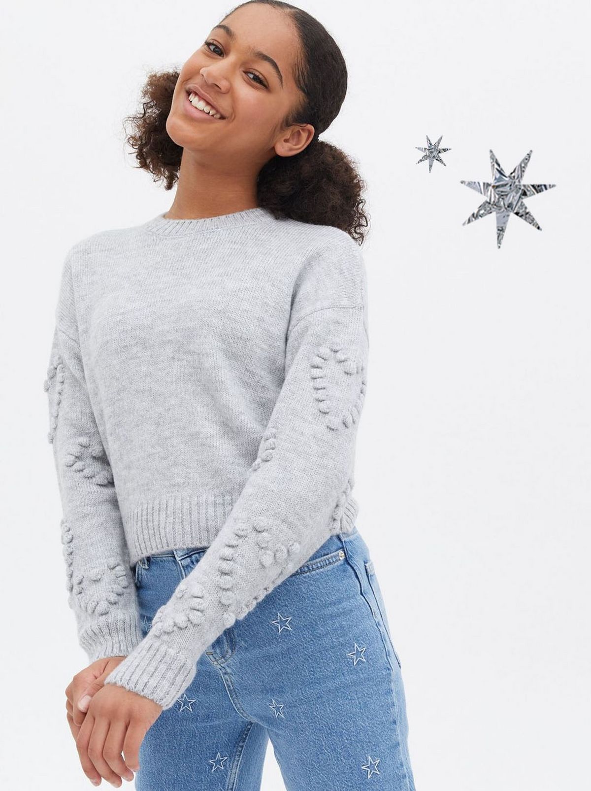 Girl wearing a grey bobble heart jumper