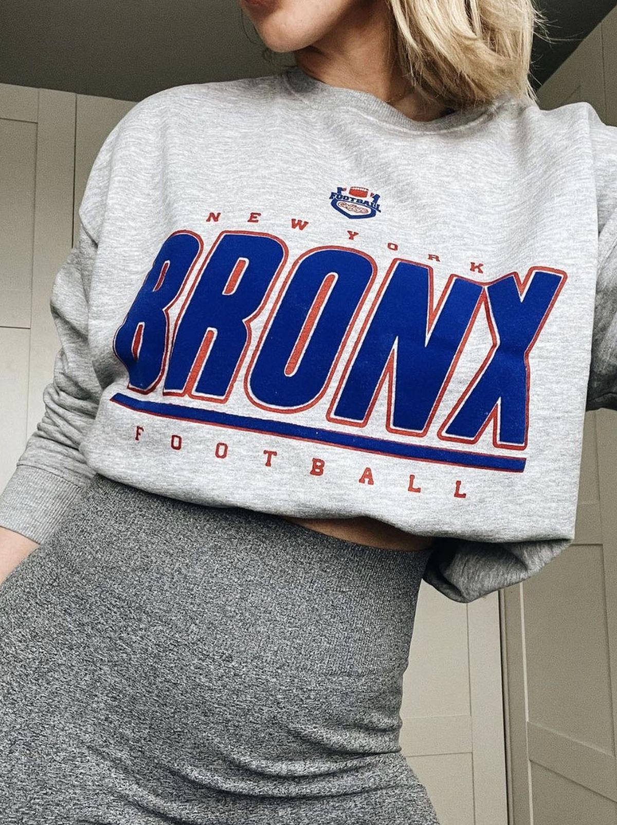 New Look's Shannon wearing a grey bronx logo jumper and grey leggings