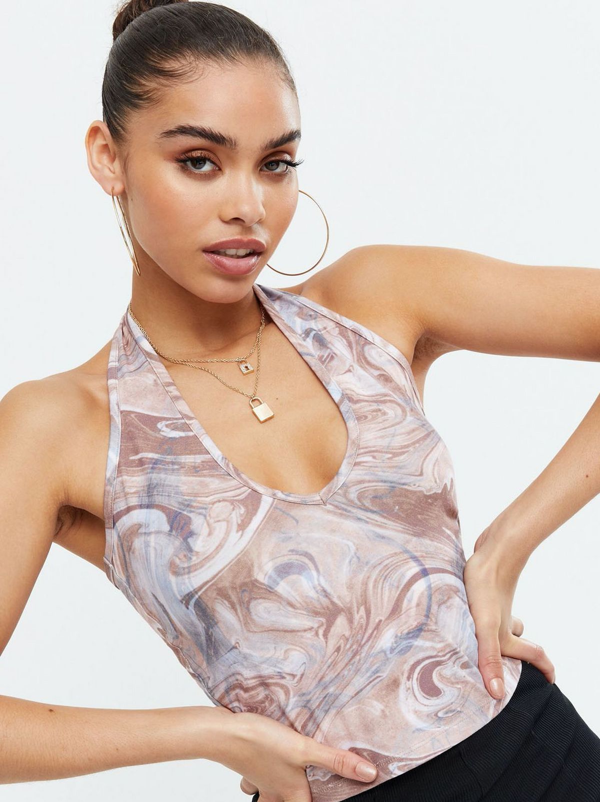 Woman wearing a brown marble print halter top with black trousers