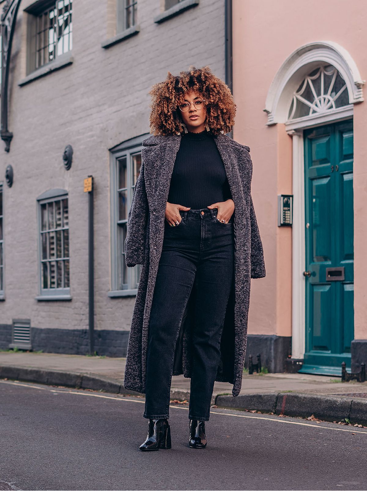 woman wearing grey faux fur maxi coat, black jeans and black high neck jumper