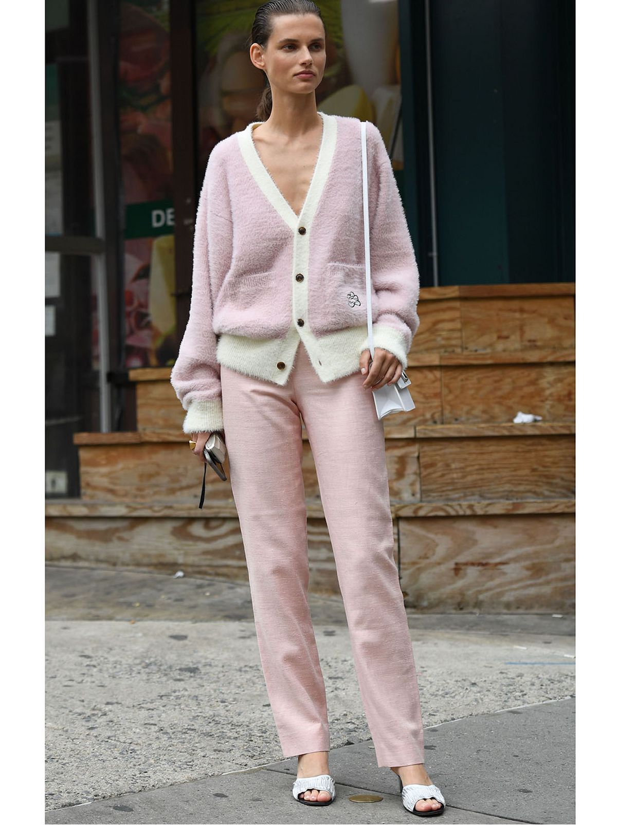 woman wears pale pink cardigan and pale pink trousers
