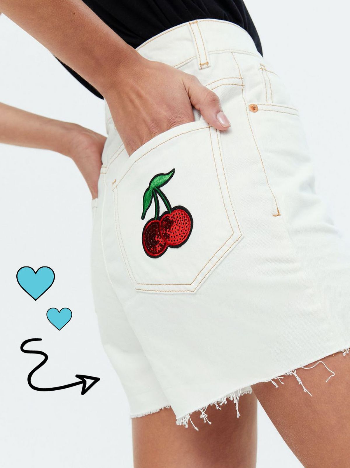 Woman wearing off white denim frayed mom shorts and black top