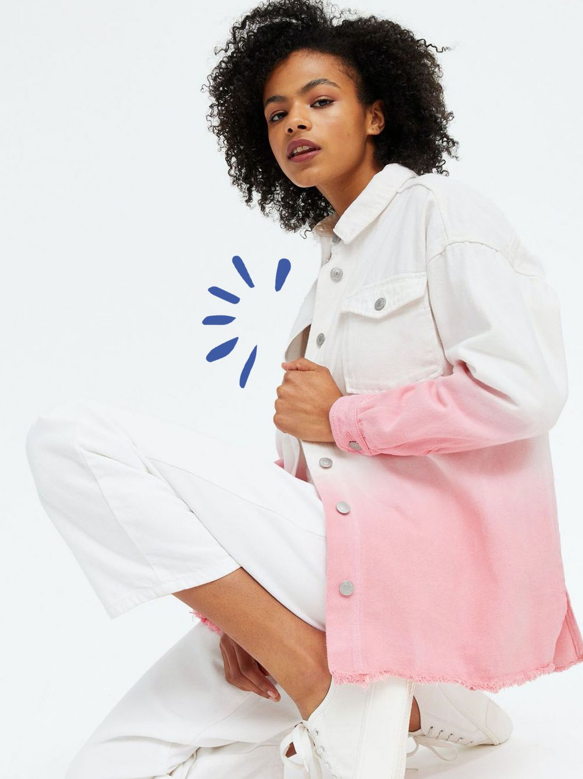 Woman wearing a pink ombre denim button up shirt, white jeans and trainers