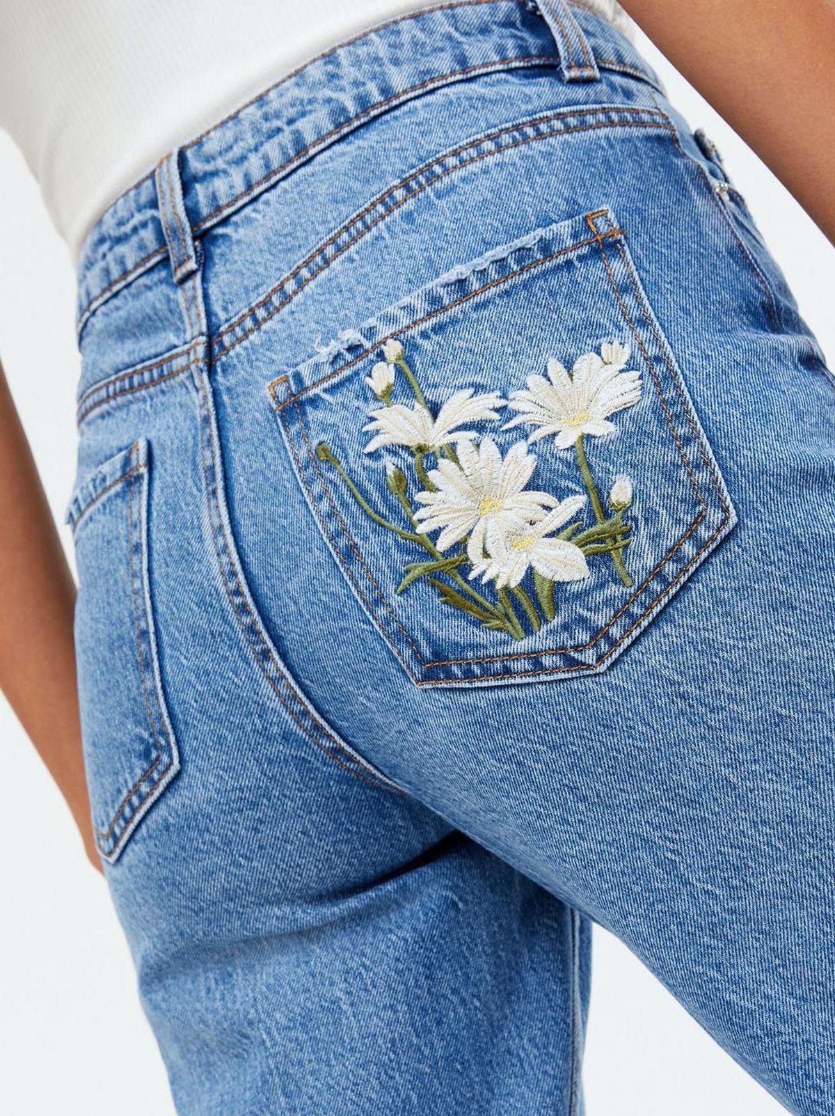 Woman wearing blue floral embroidered high waist mom jeans