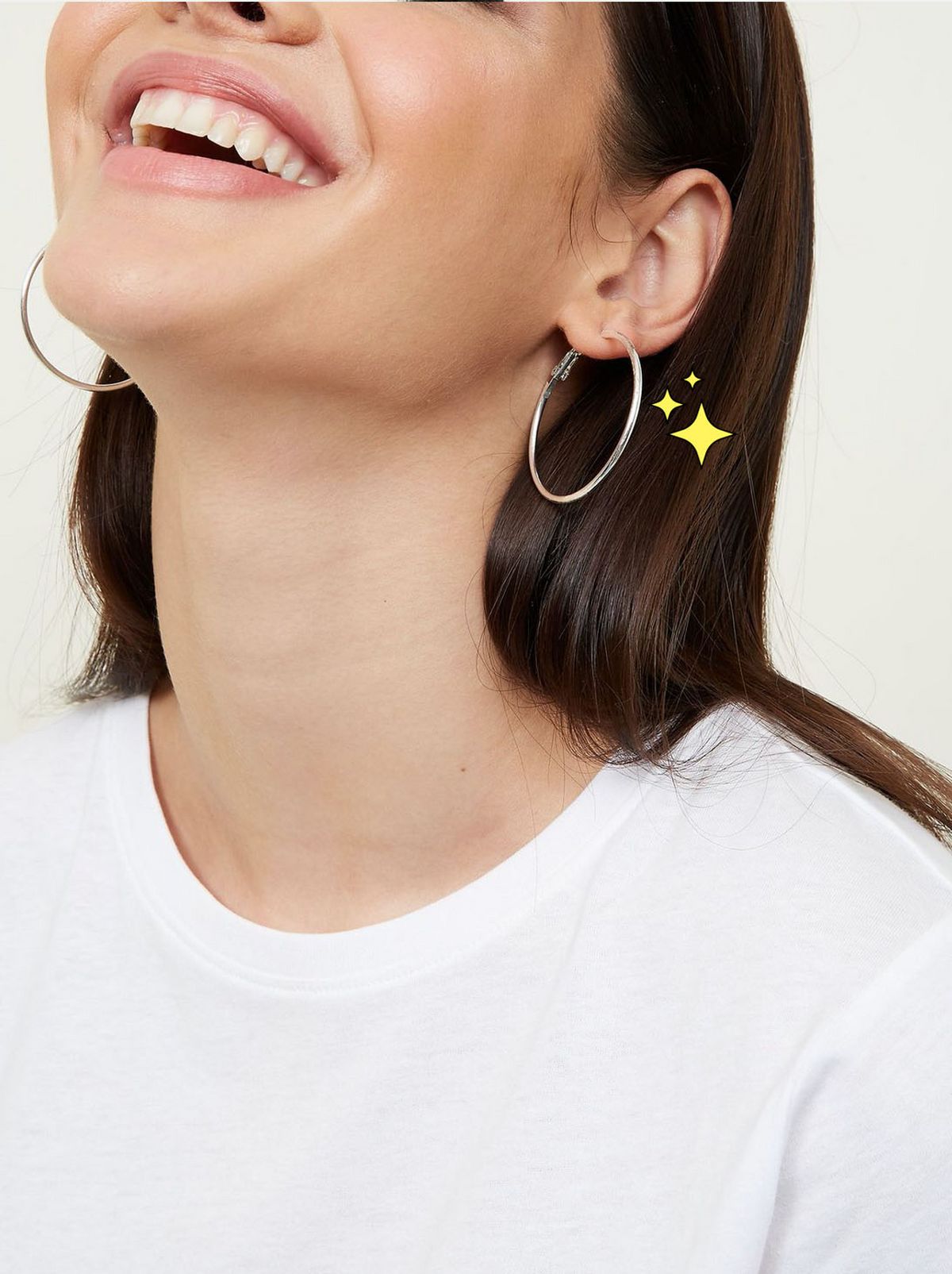 Woman smiling wearing gold and silver hoop earrings