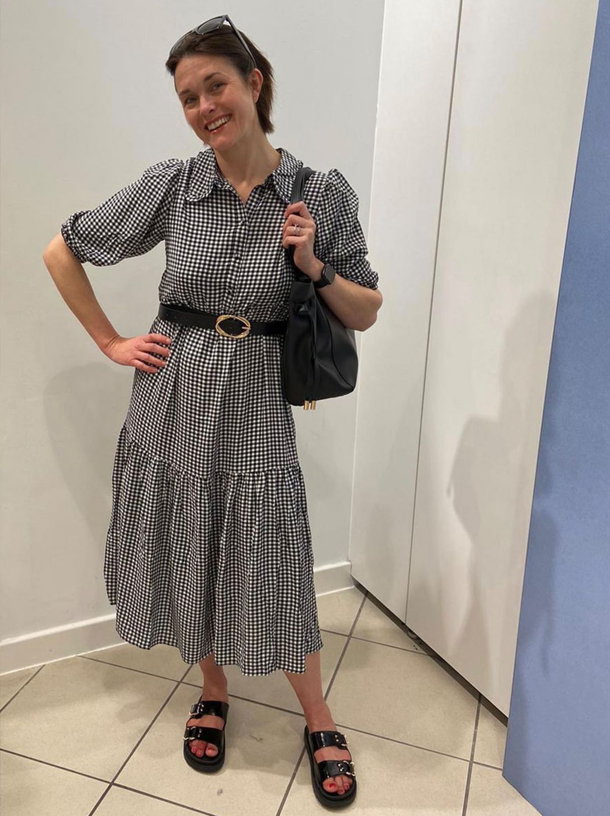 Jo Jones, Sales Advisor at New Look Bromley wearing a black and white checked midi dress and black sandals