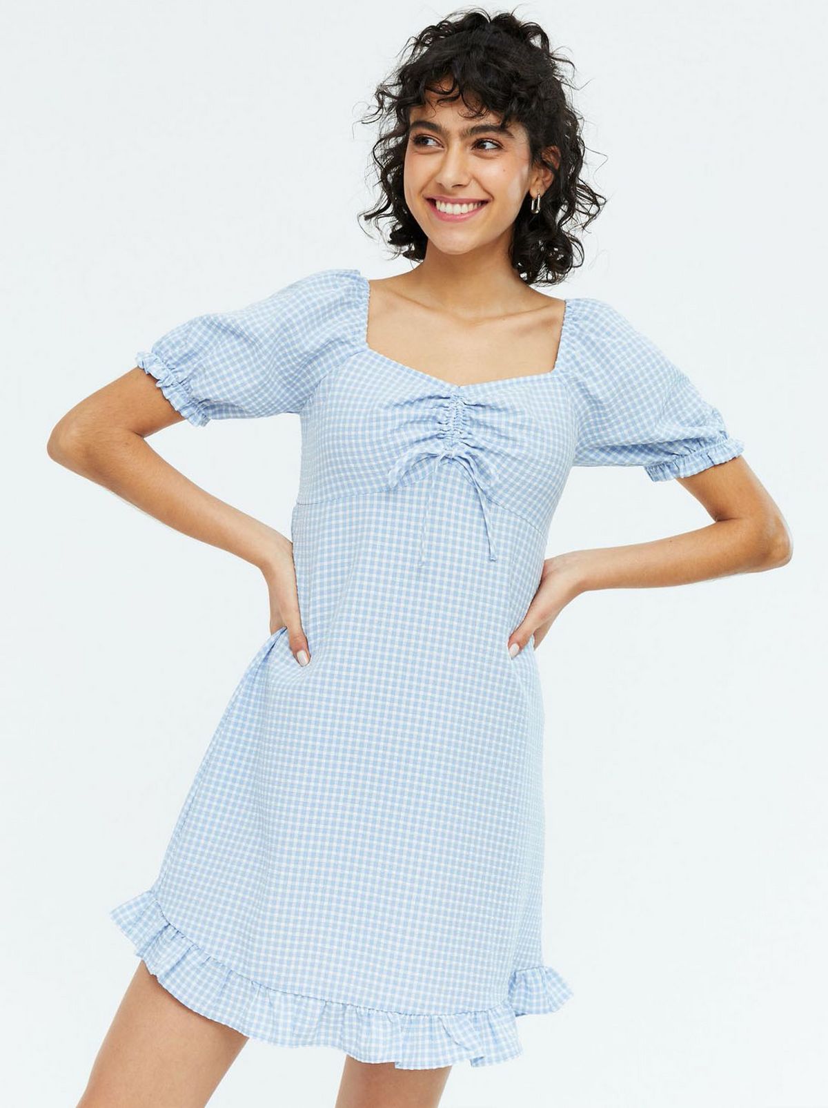 Woman wearing a blue gingham mini dress