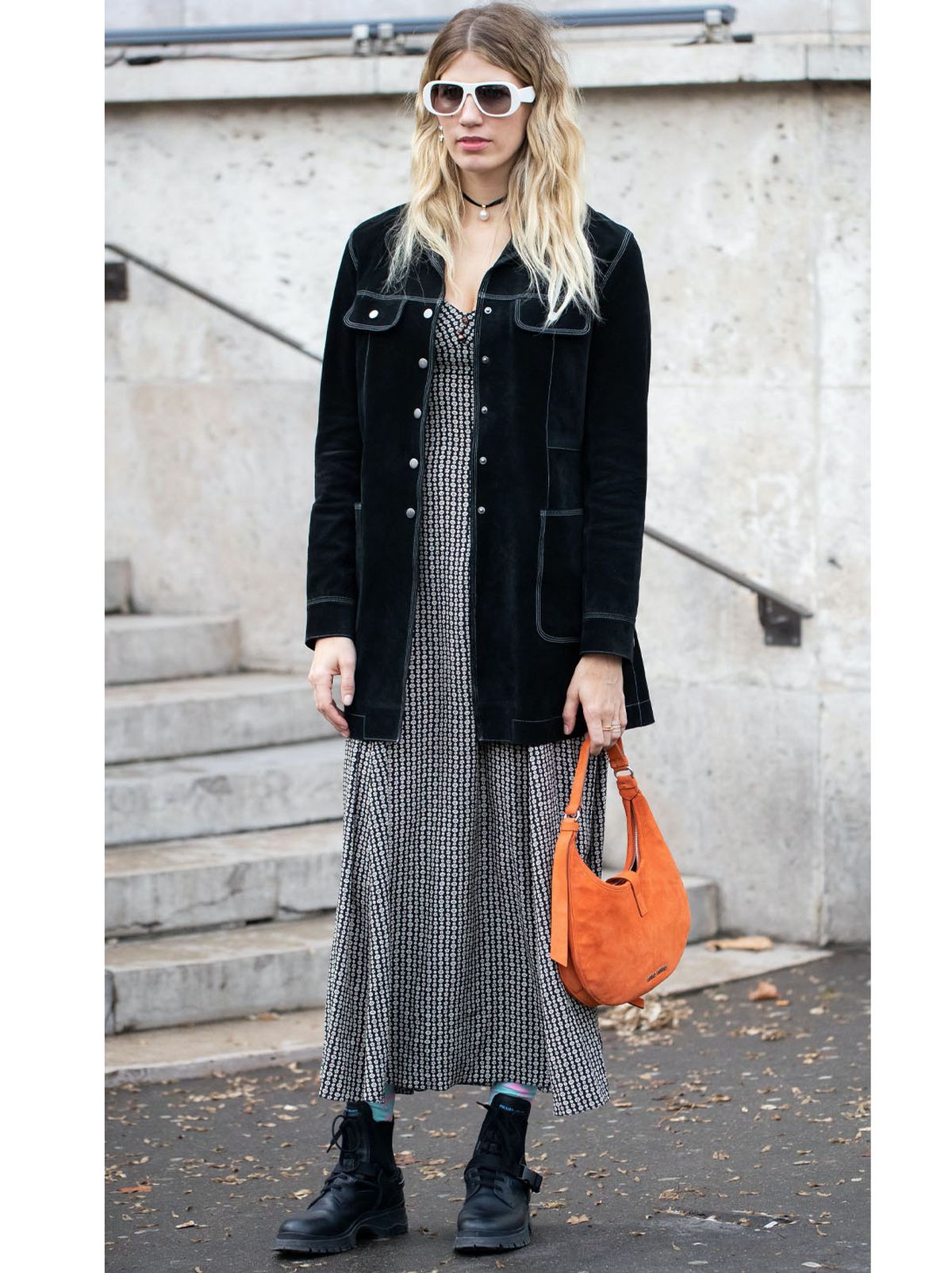 Veronika Heilbrunner wearing a patterned midi dress, black jacket and black ankle boots