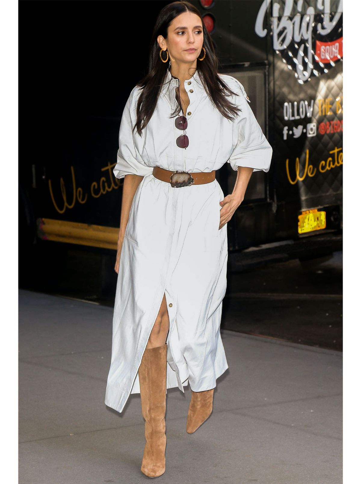 Nina Dobrev wearing a grey puff sleeve midi dress and brown knee high boots