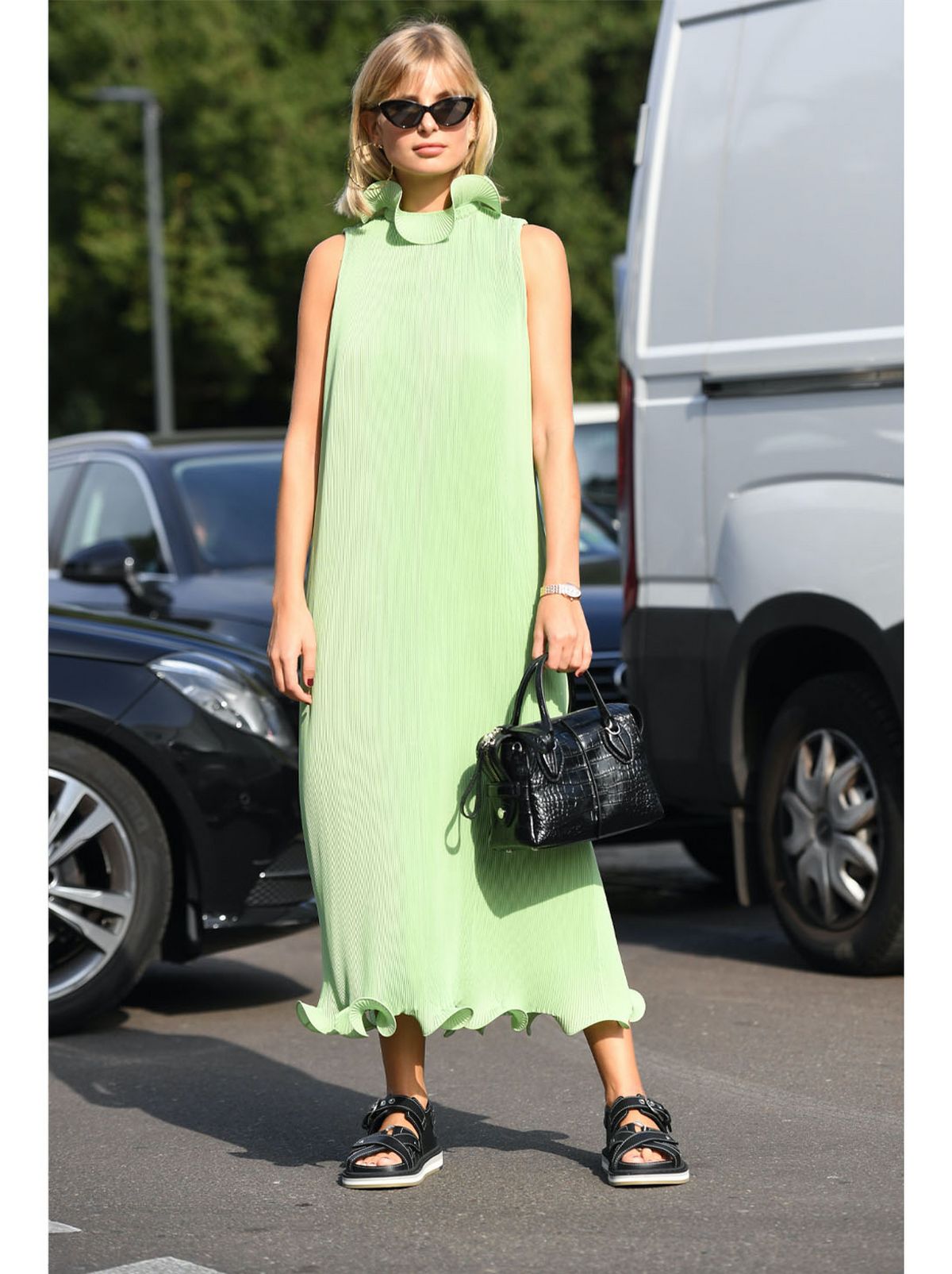 Xenia Adonts wearing a bright green midi dress and sandals