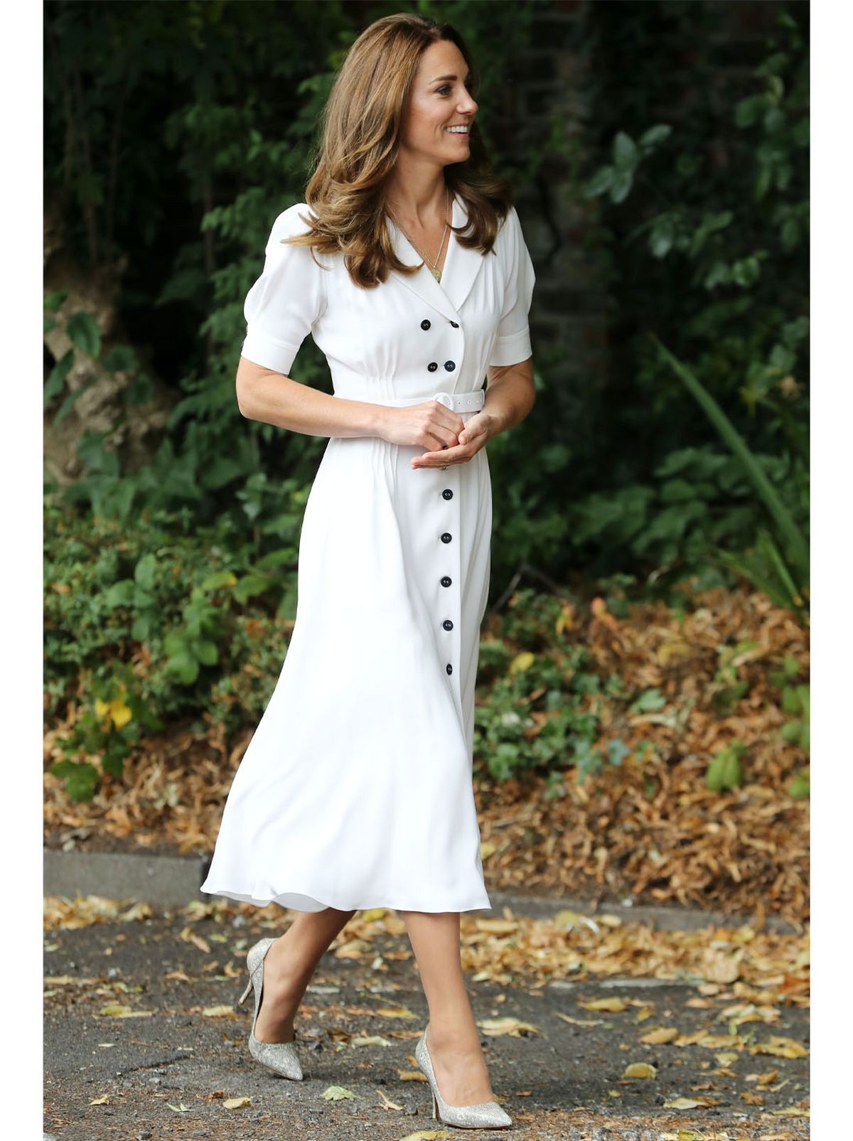 Kate Middleton wearing a white button down midi dress and heels