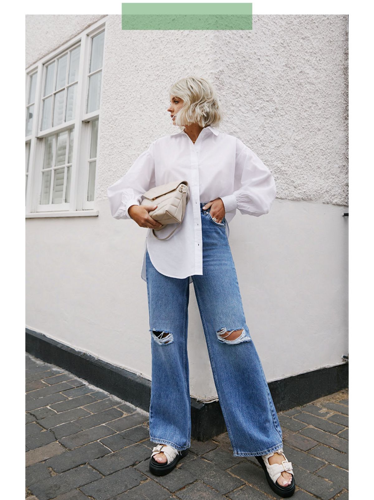 Laura B wearing a white button up shirt, blue wide leg ripped jeans and platform sandals.