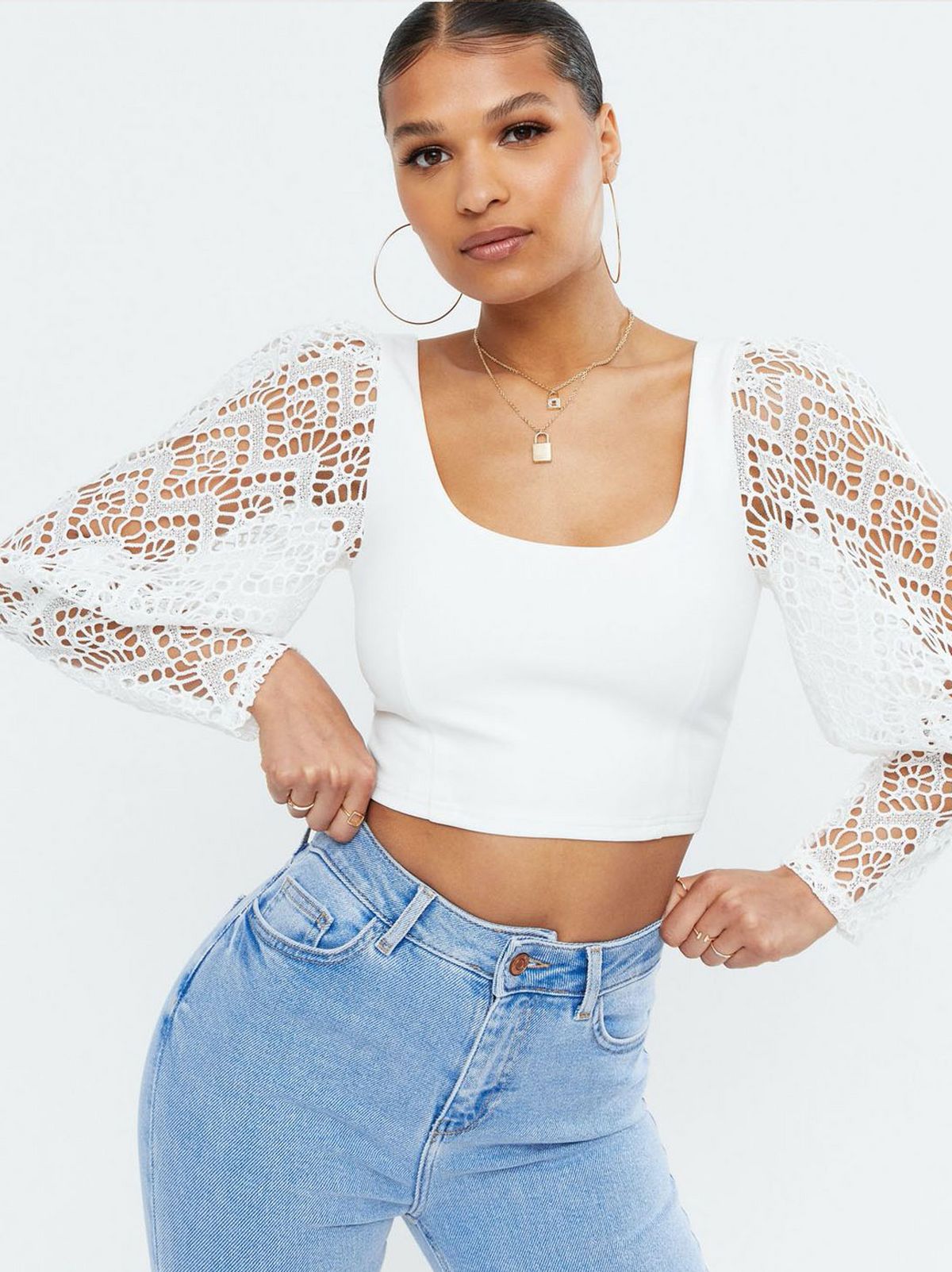 Woman wearing a White Broderie Puff Sleeve Crop Top and blue jeans