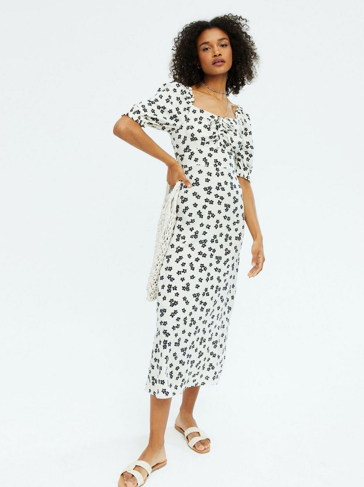 Woman wearing a White Floral Sweetheart Midi Dress and white sandals