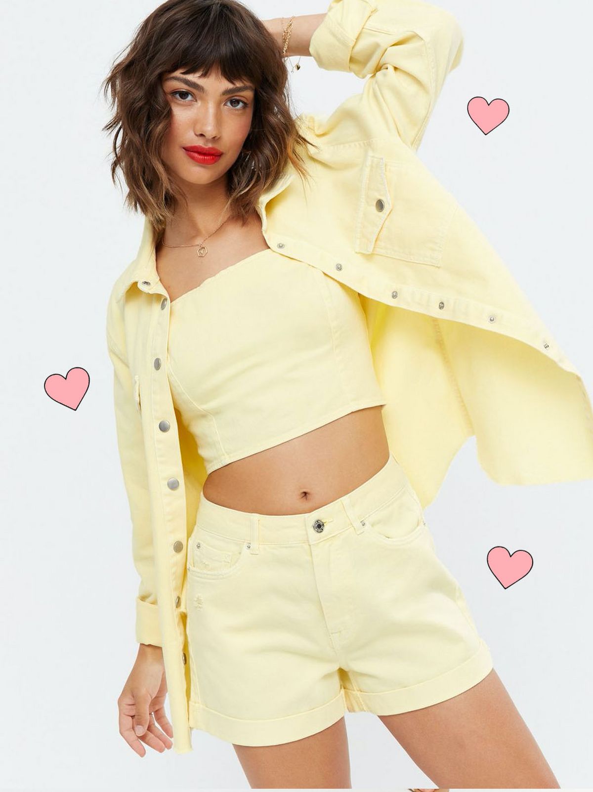 Woman wearing a yellow denim oversized shirt, yellow crop top and yellow denim shorts