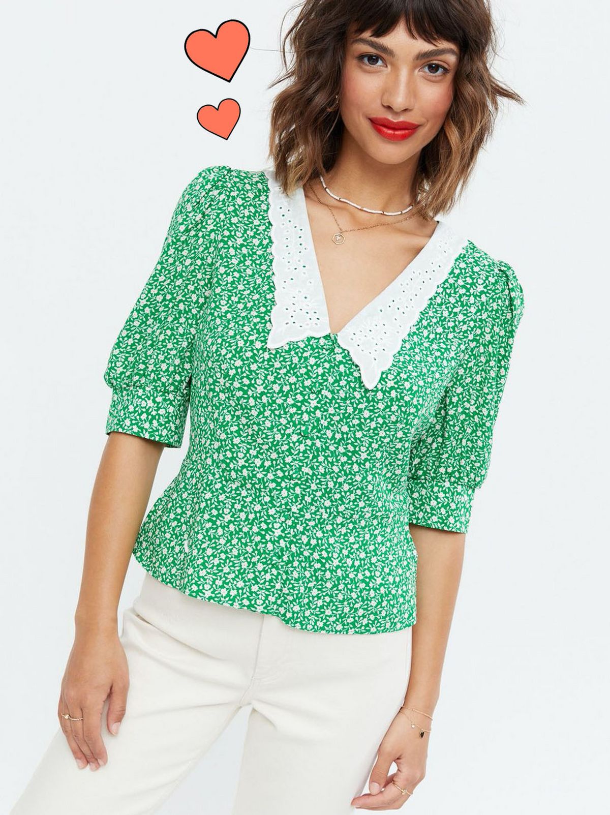Woman wearing a green floral blouse and white jeans