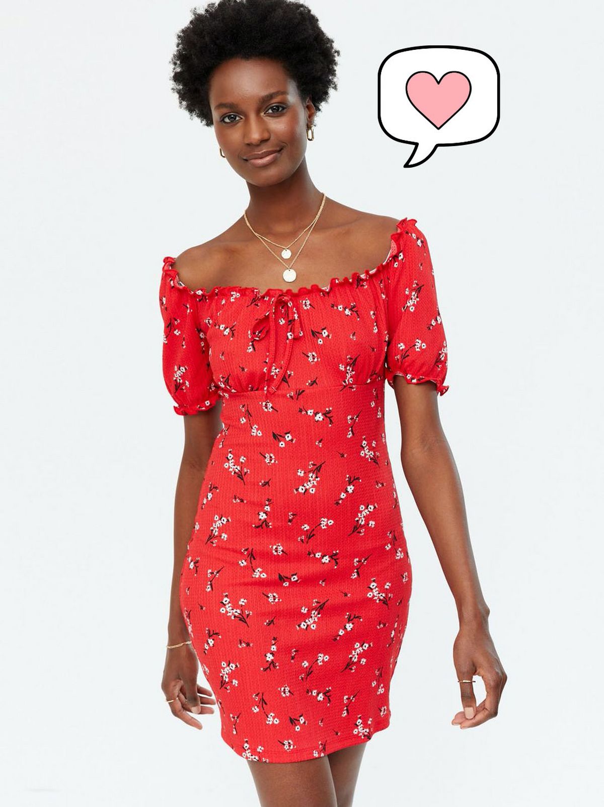 Woman wearing a red floral bardot mini dress with a gold necklace