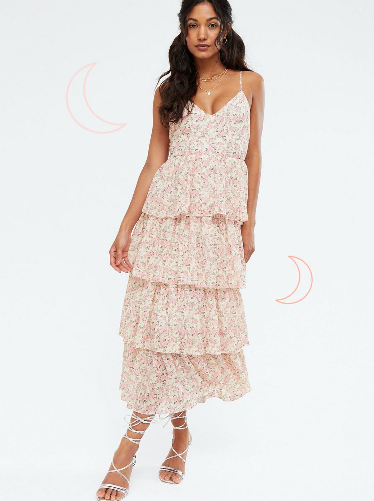 Woman wearing a pink ditsy floral tiered tie back midi dress and strappy heels