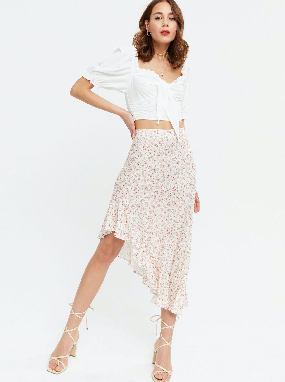 Woman wearing a white ditsy floral midi skirt with a white puff sleeve top