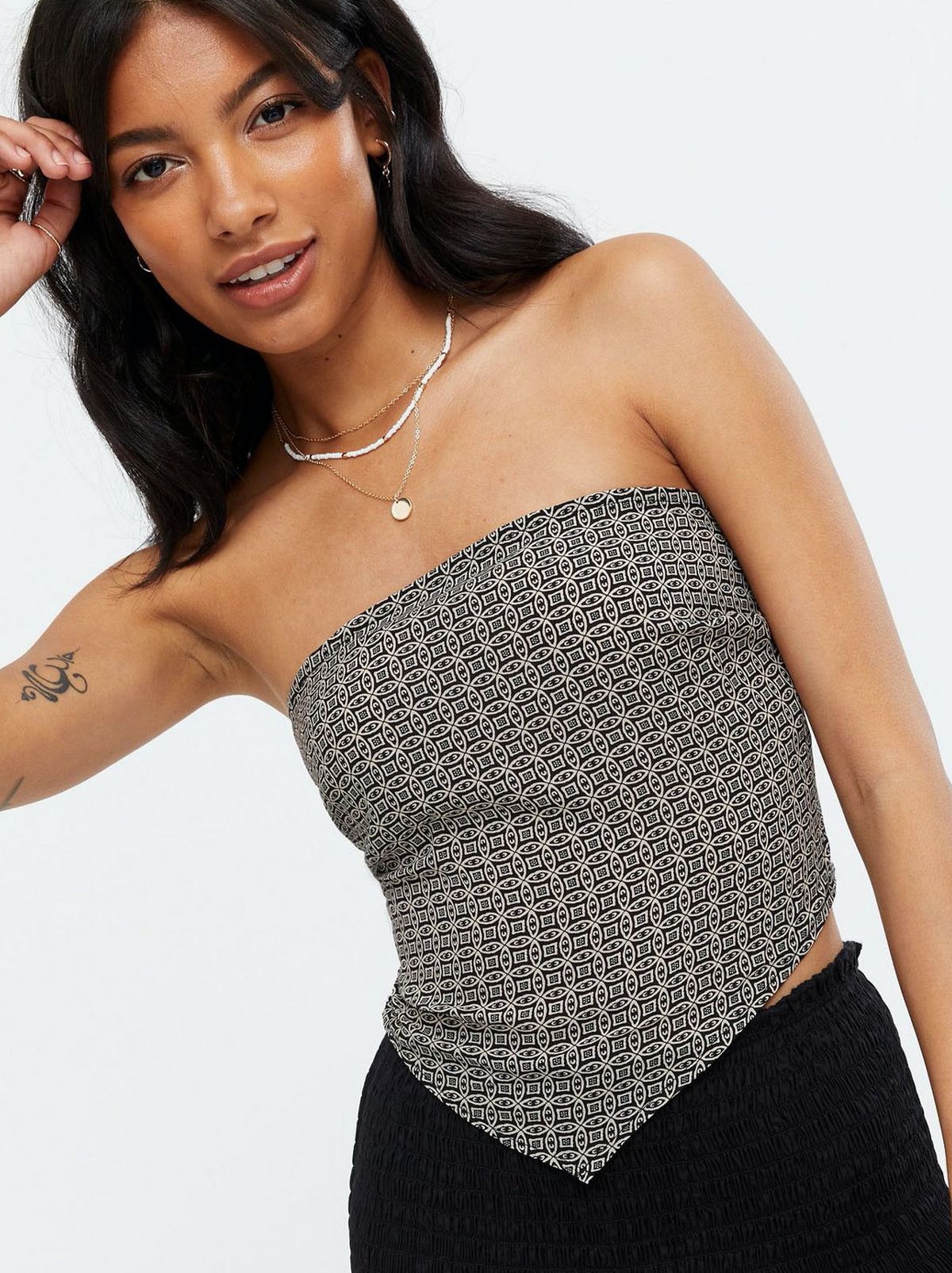 Woman wearing a black geometric print scarf crop top