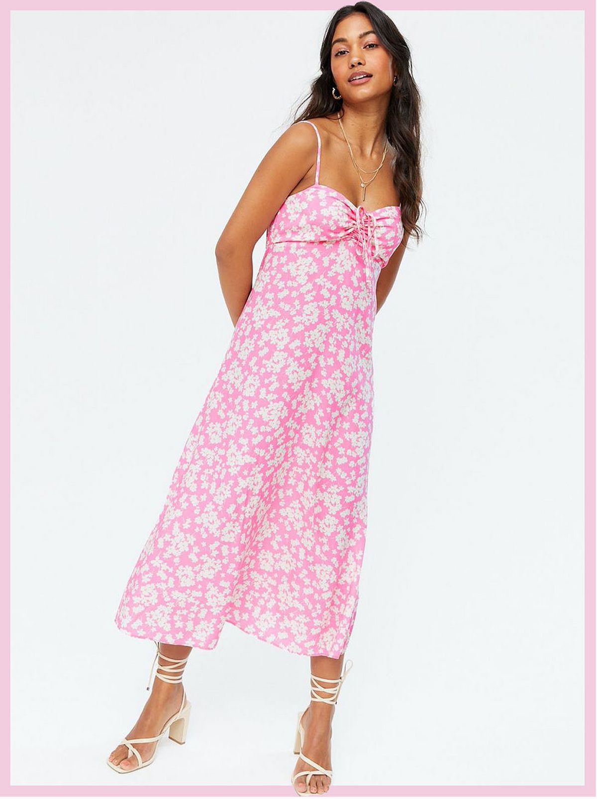 Woman wearing a pink floral tie front midi slip dress and strappy heels