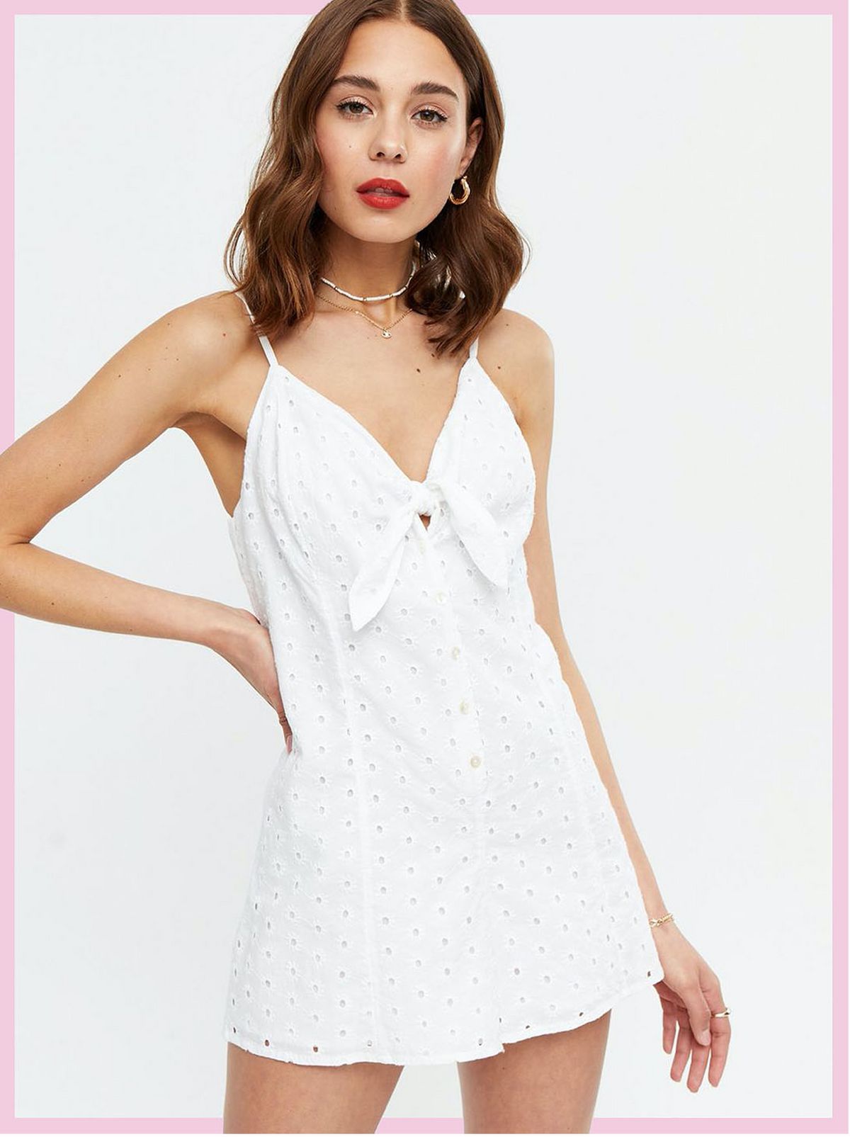 Woman wearing a white broderie tie front playsuit