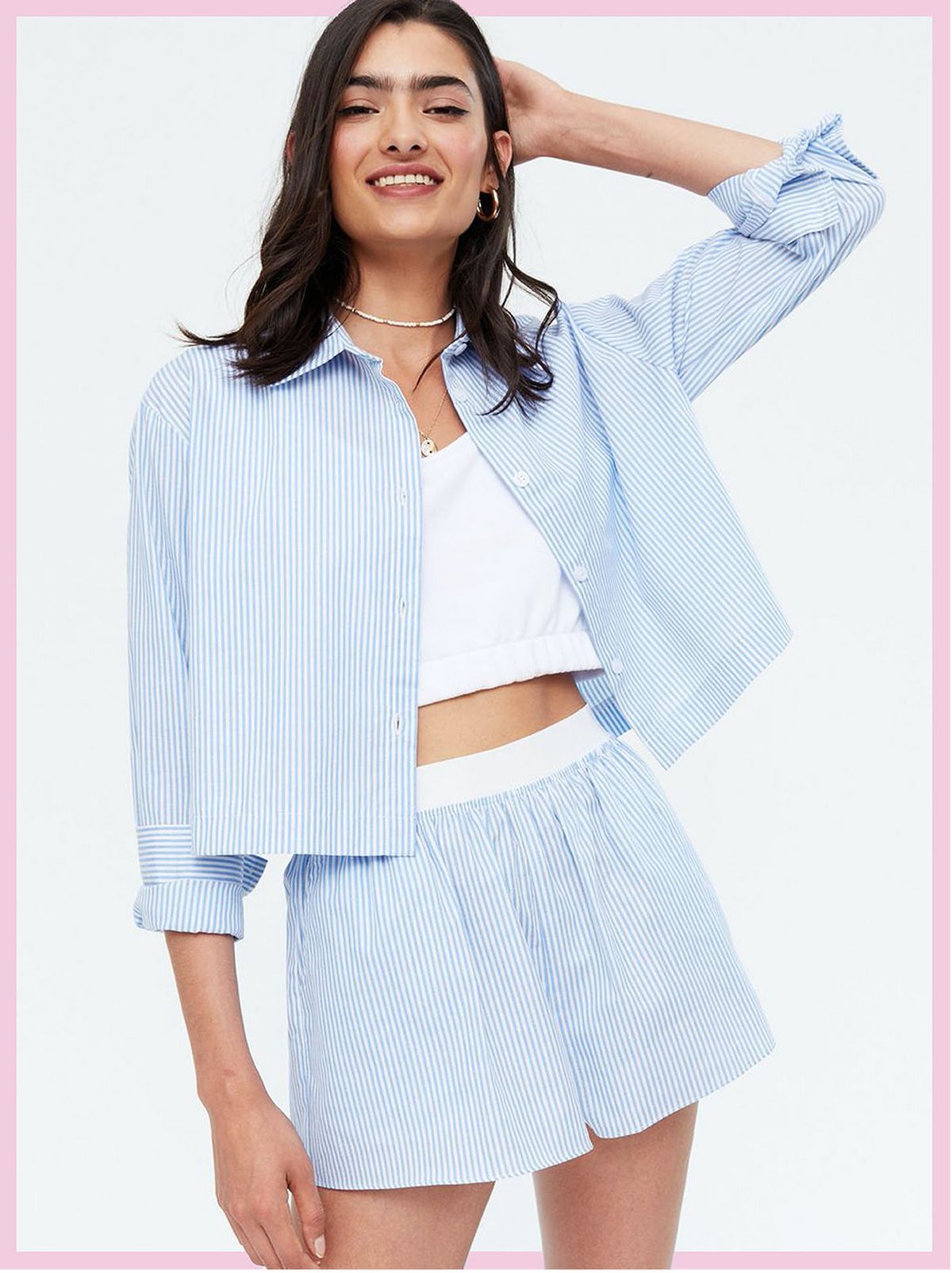 Woman wearing a pale blue stripe poplin shirt and matching shorts with a white crop top