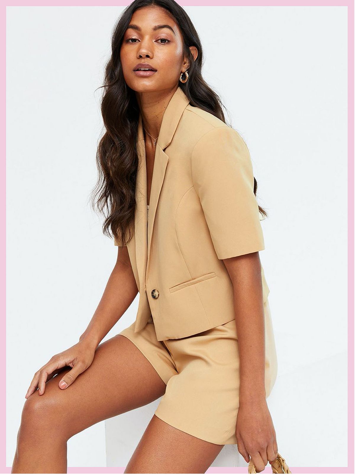 Woman wearing a camel short sleeve crop blazer and matching shorts