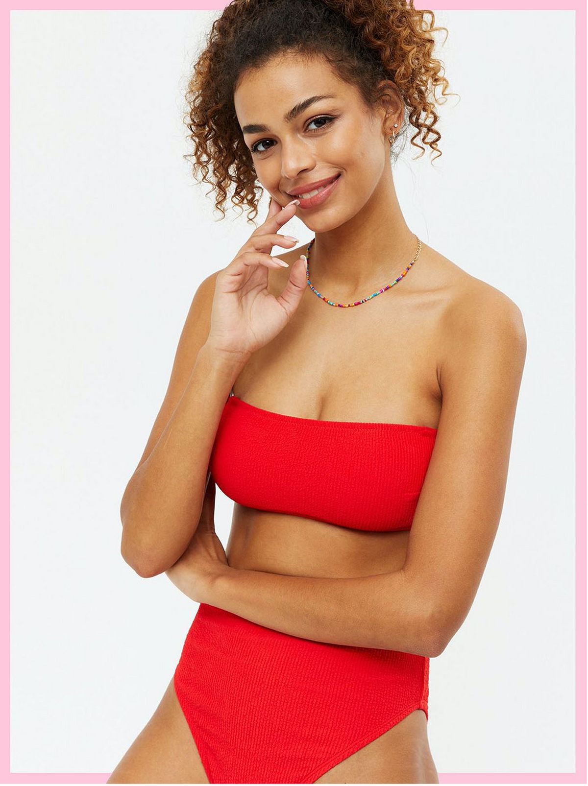 Woman wearing a red textured bandeau bikini top and matching bottoms