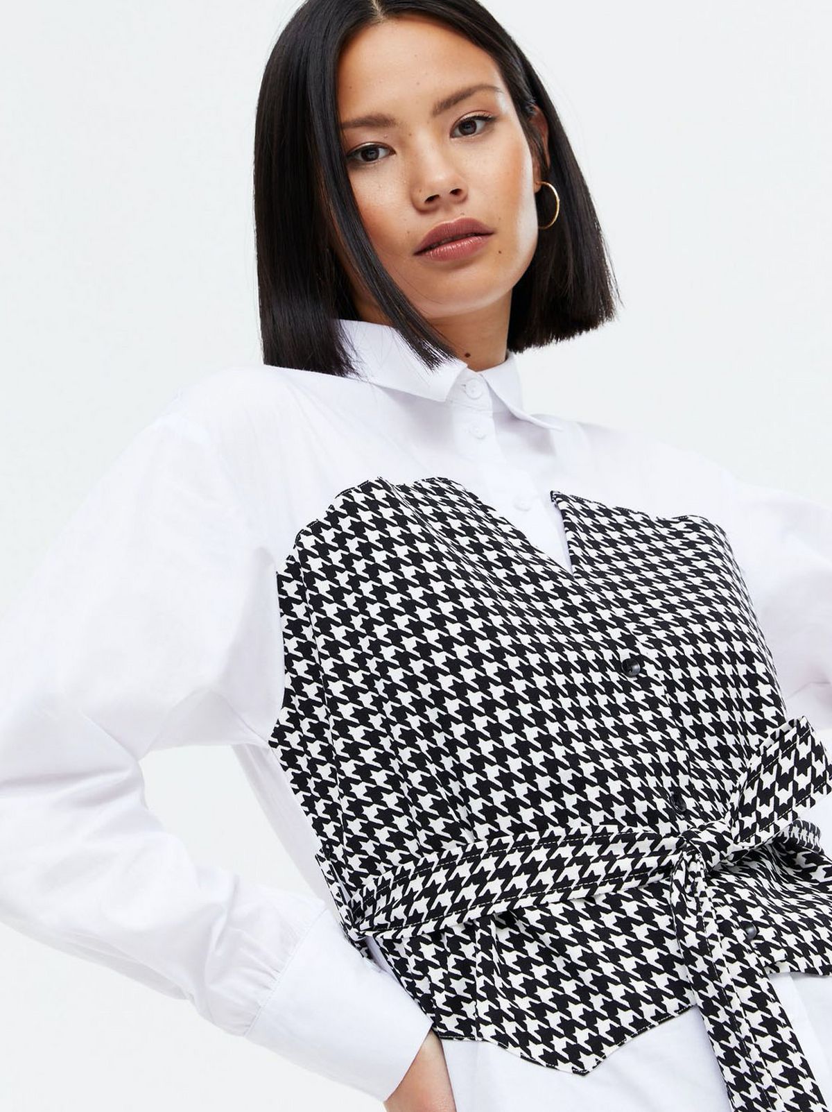 Woman wearing a white dogtooth 2 in 1 corset shirt