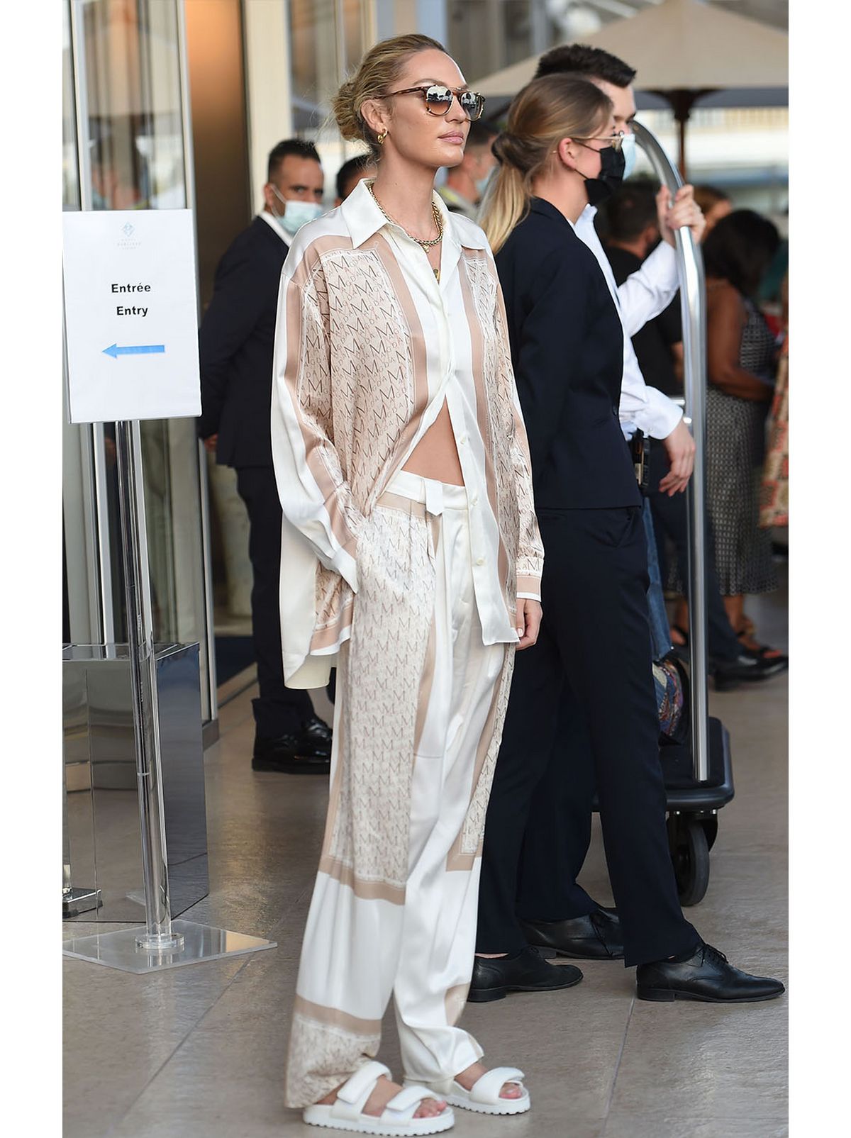 Candice Swanepoel wearing a satin oversized shirt co-ord set and sandals