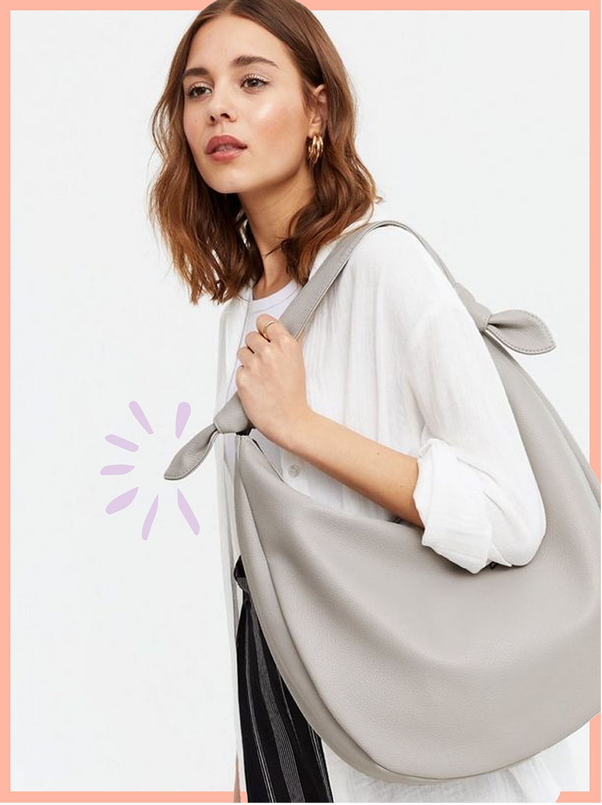 Woman carrying a pale grey leather-look slouchy tote bag wearing a white cardigan