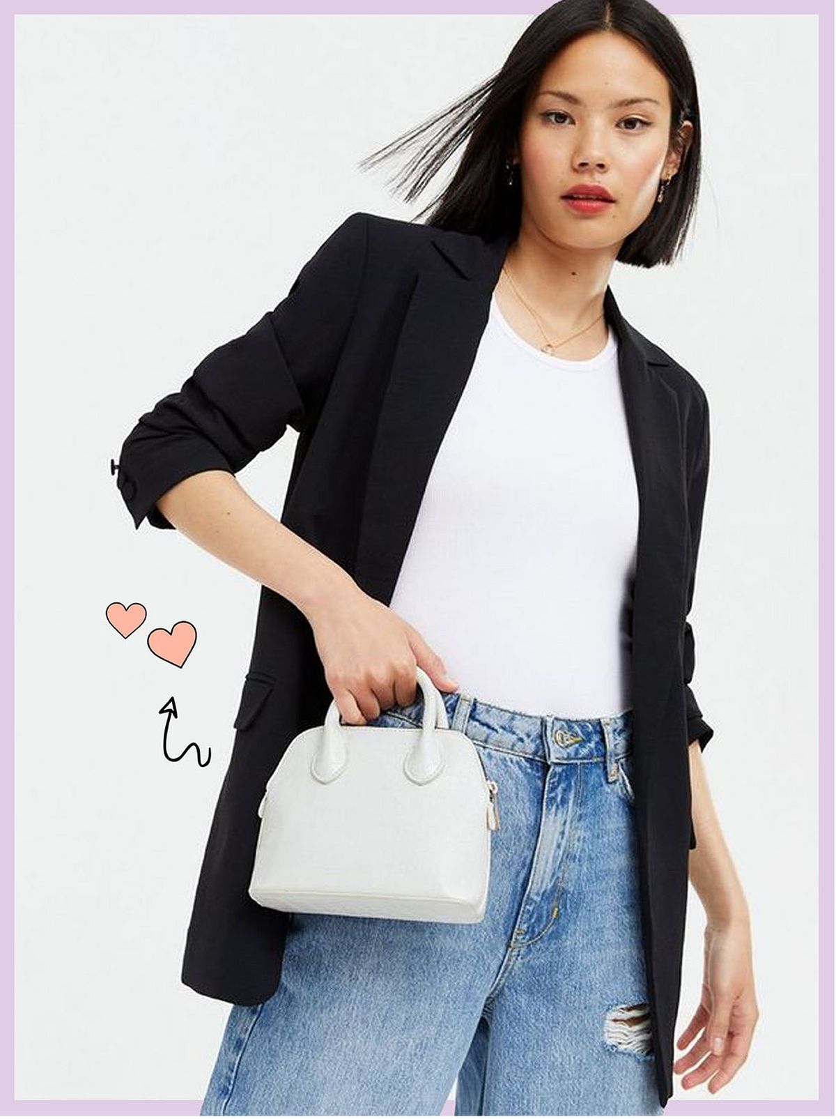 Woman carrying a white faux croc mini cross body bag wearing a black blazer, white t-shirt and blue jeans
