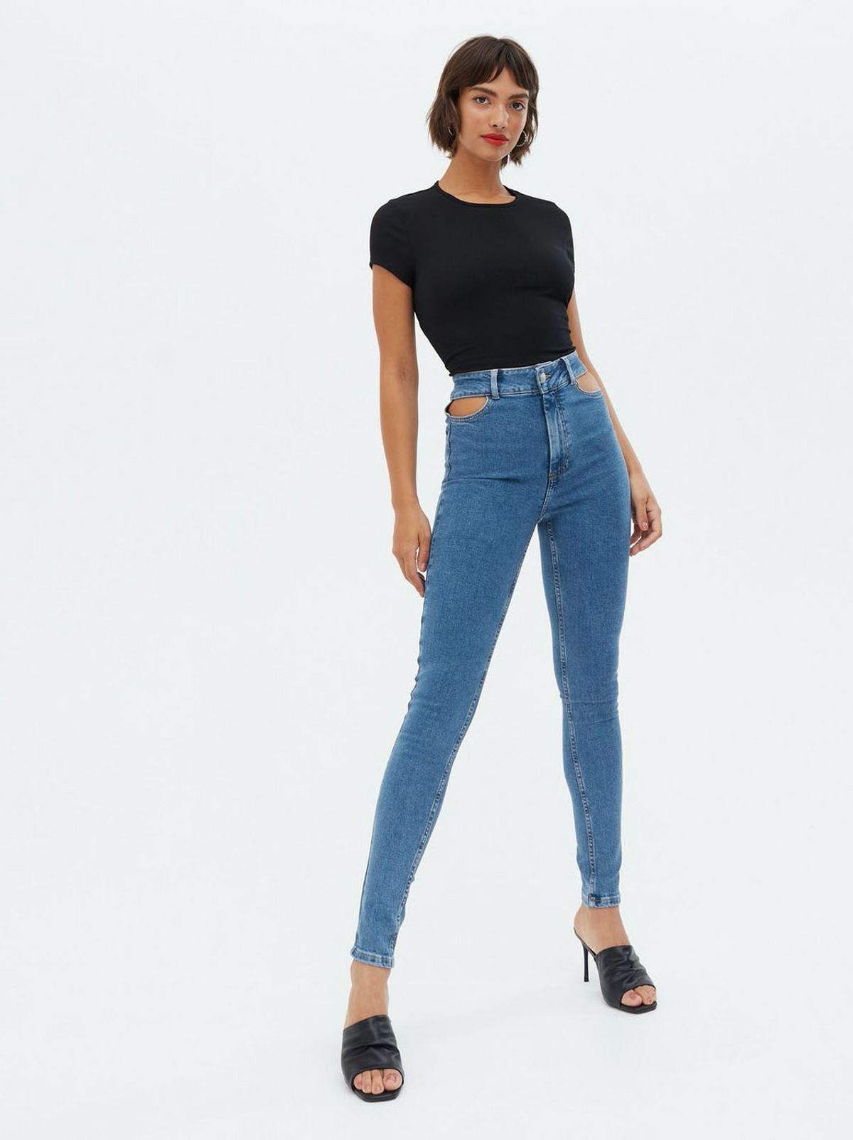 Woman wearing blue high rise skinny jeans, black t-shirt and heels