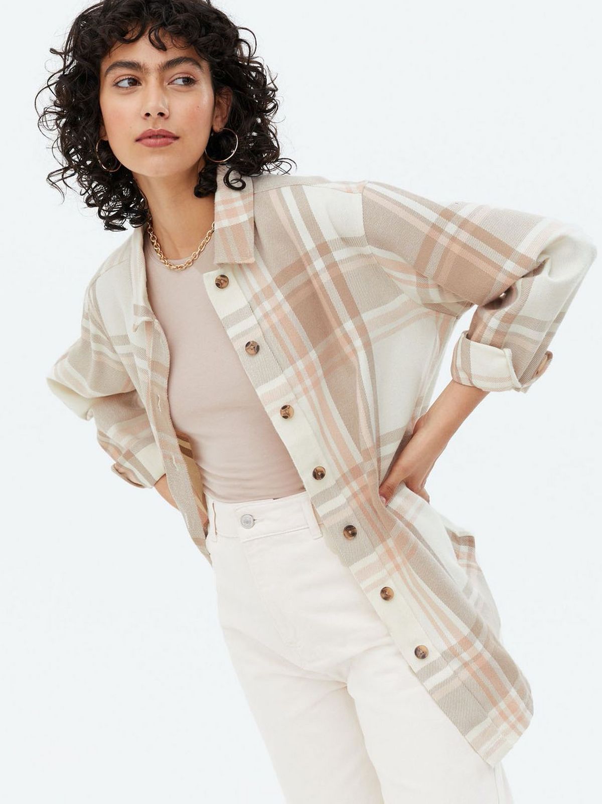 Woman wearing a white check brushed oversized shirt, cream t-shirt and white jeans