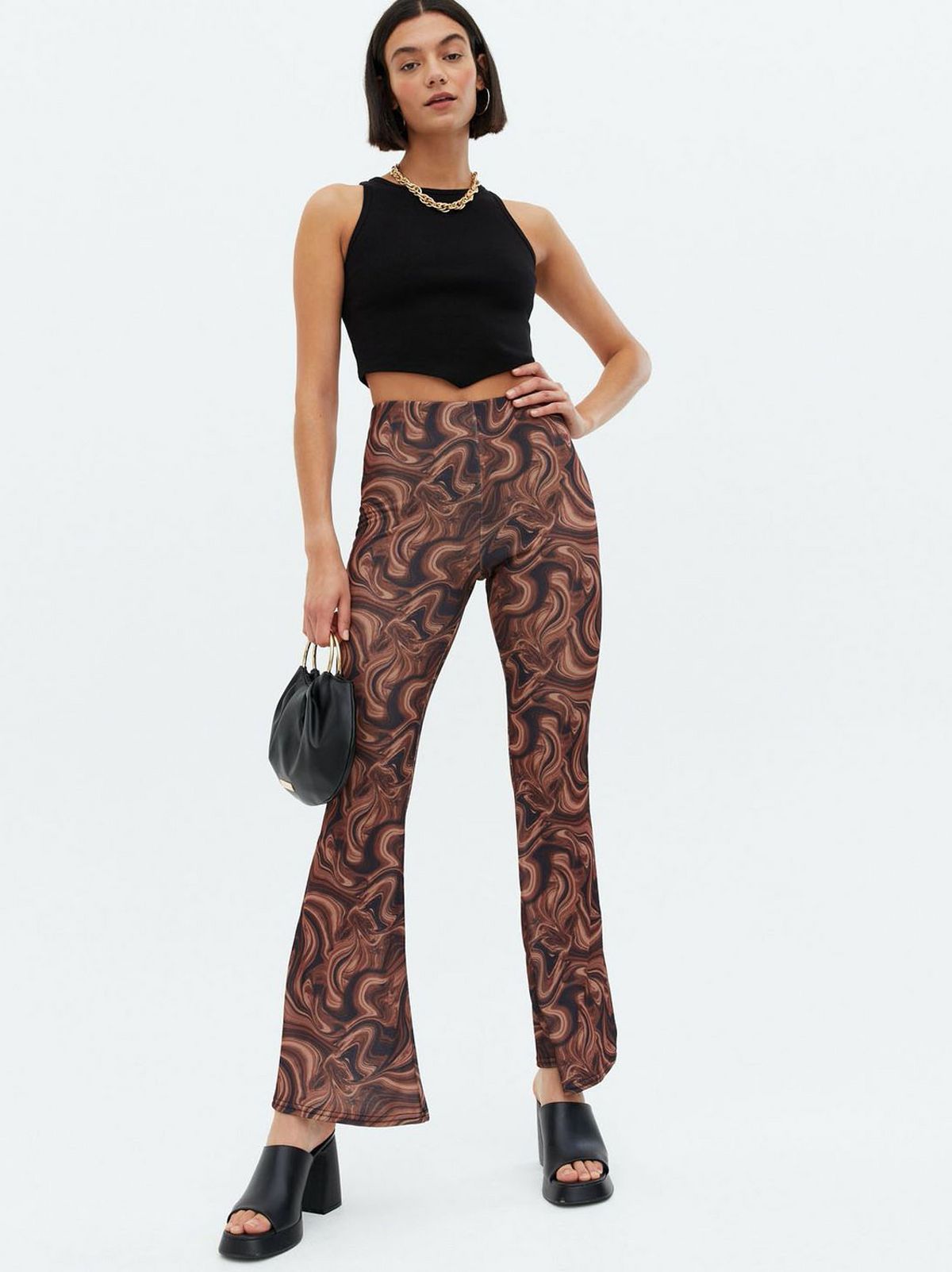 Woman wearing brown marble crepe flared trousers, black top and heels