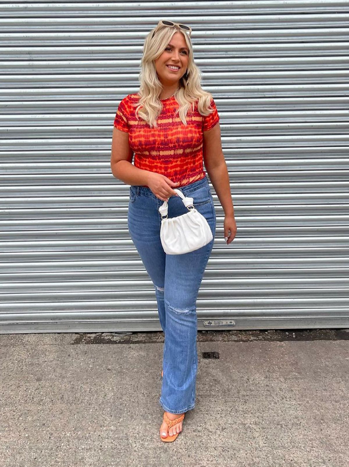 New Look's Lauren Cosier wearing a red t-shirt with blue flared jeans