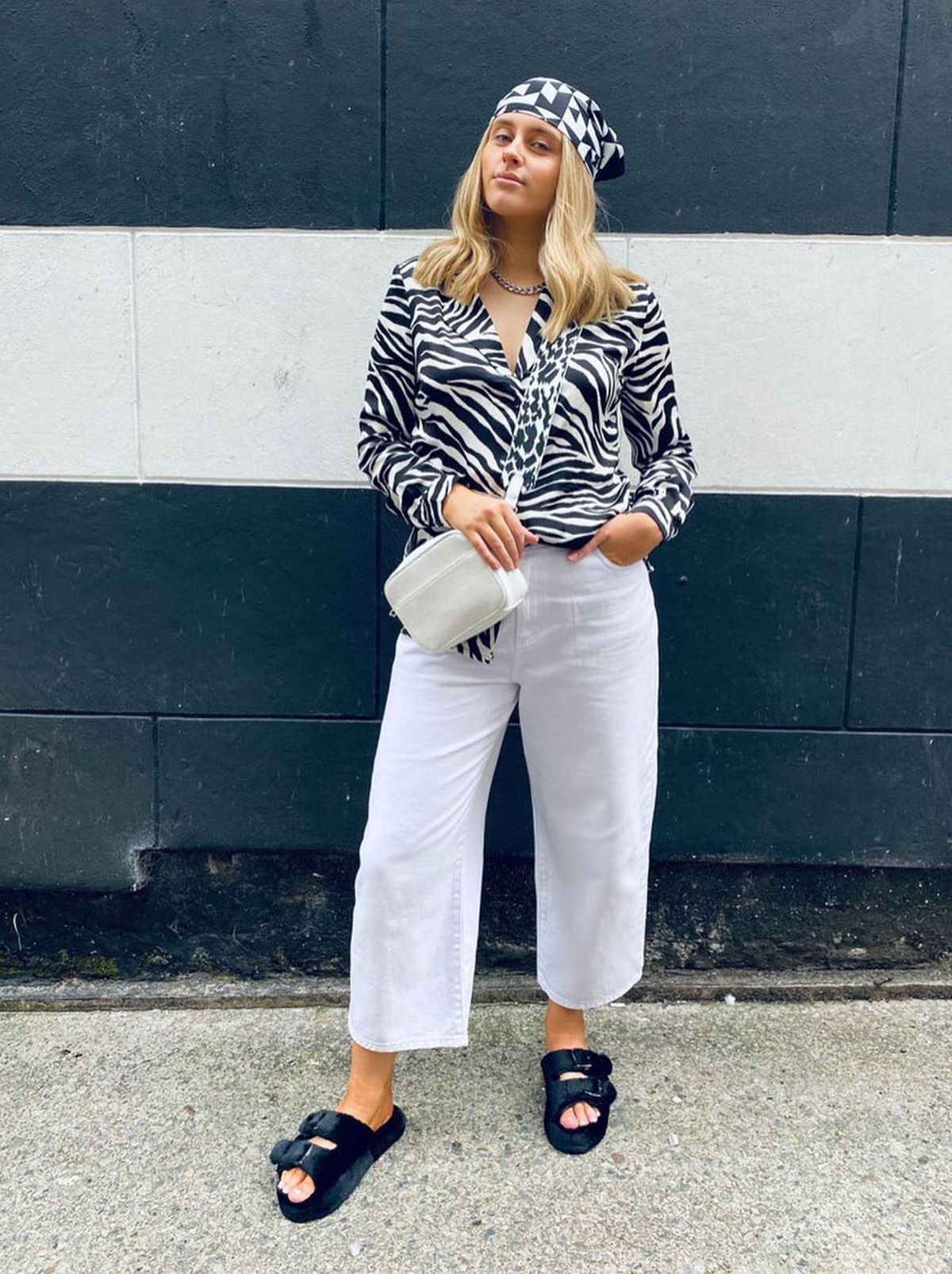 New Look's Nia Minnery wearing a black and white animal print shirt, white trousers and bandana