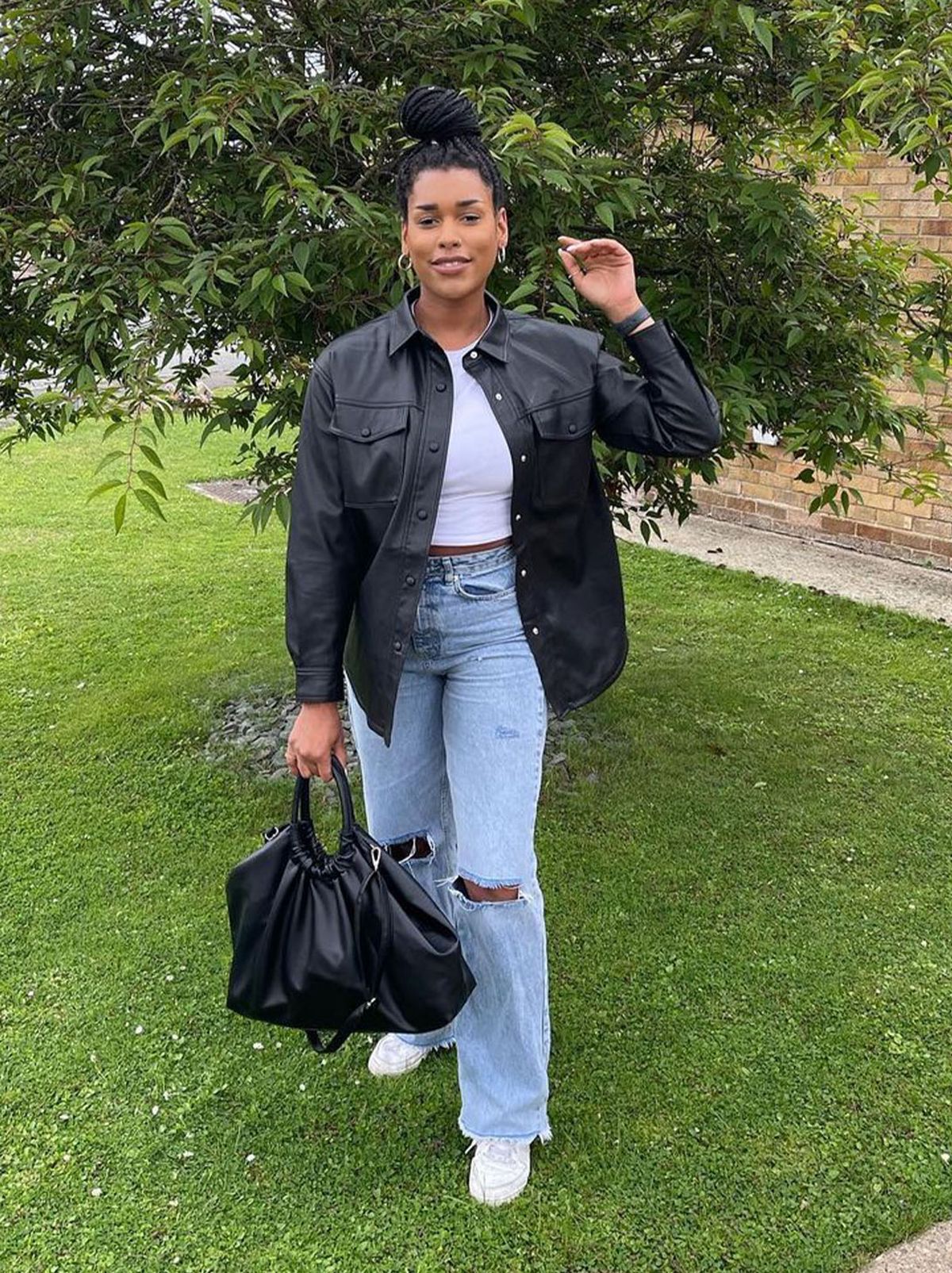 New Look's Jasmine Saunders wearing ripped blue jeans, white top and a black jacket