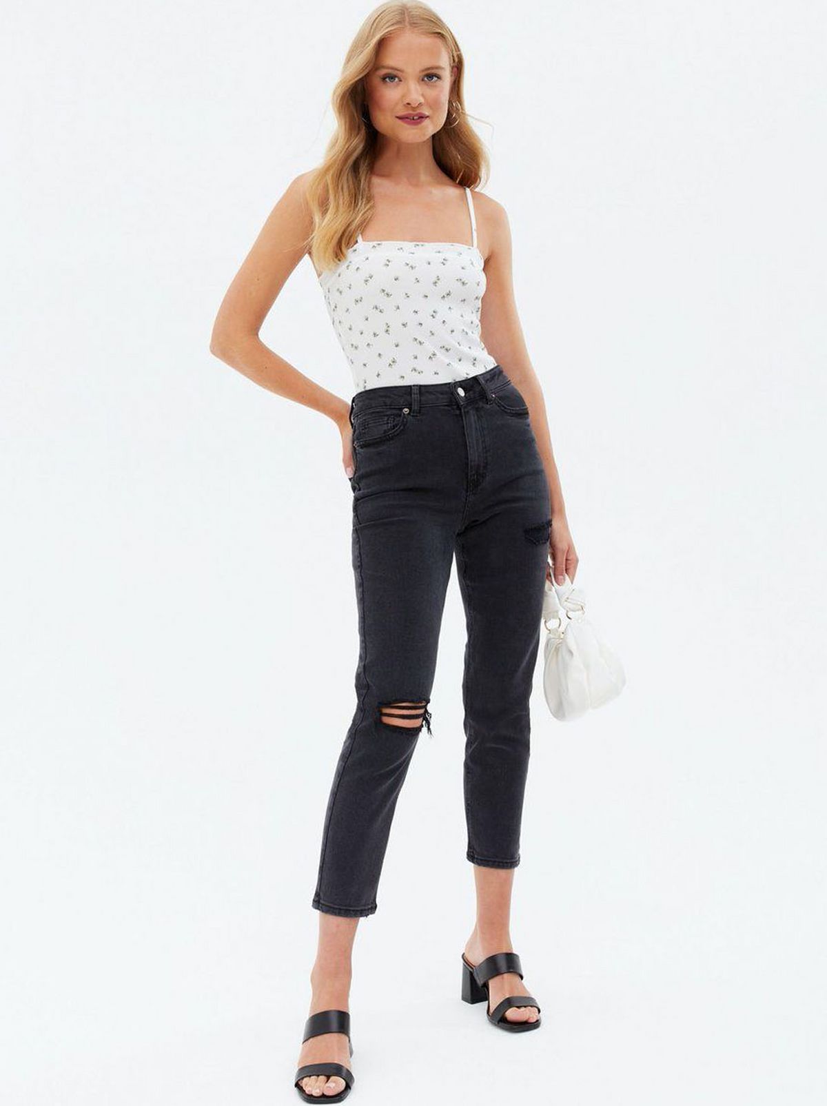 Woman wearing black dark wash ripped mom jeans, cami top and heeled sandals