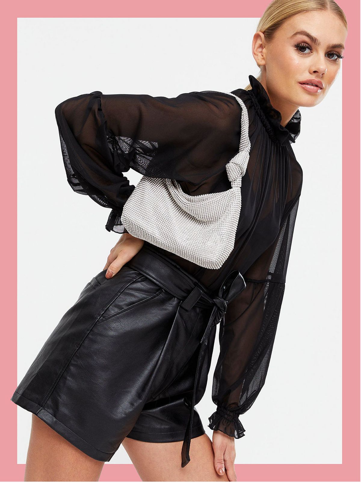 Woman carrying a sliver diamante knot shoulder bag, a mesh top and black shorts