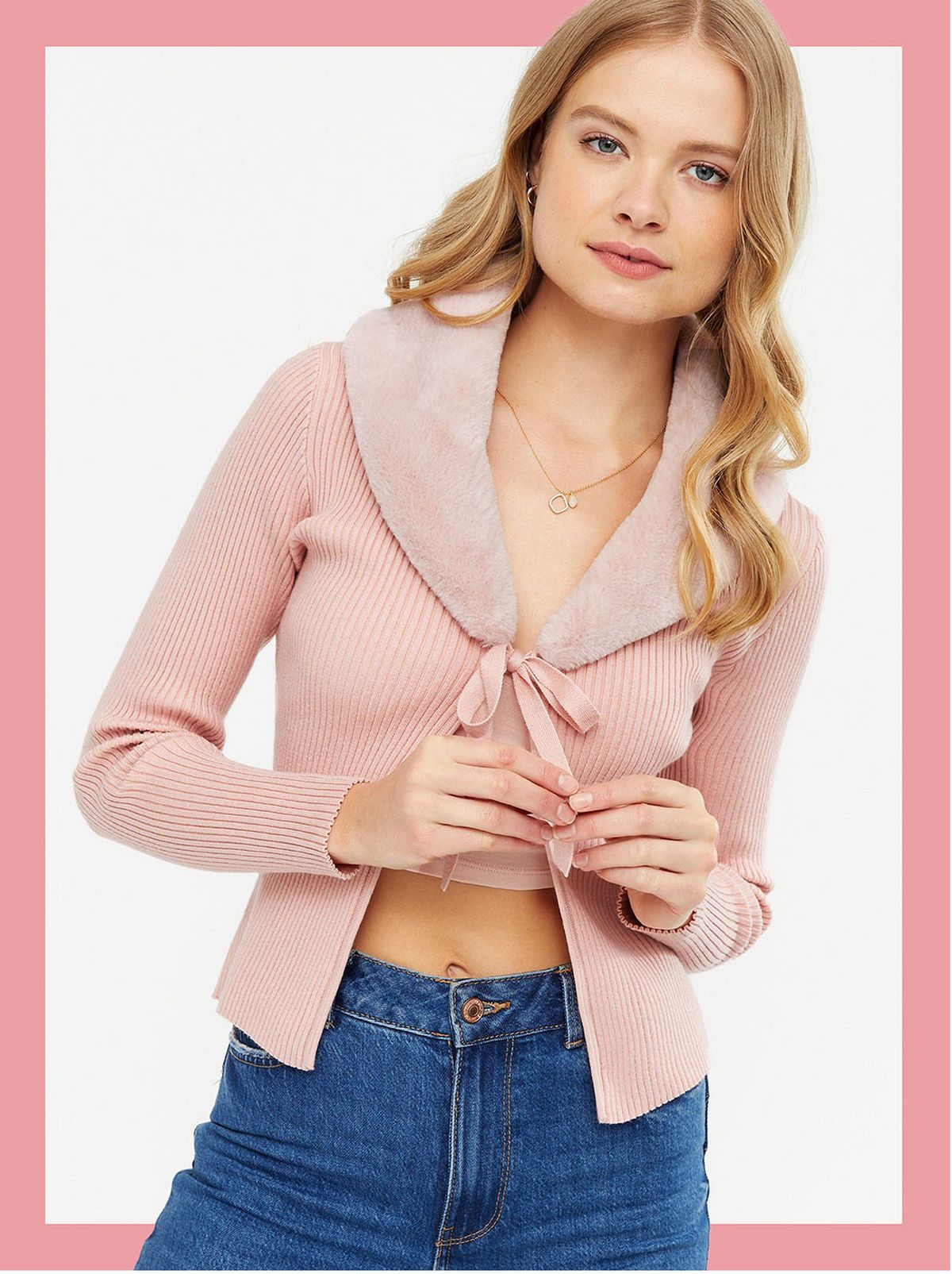 Woman wearing a pink faux fur cardigan and jeans
