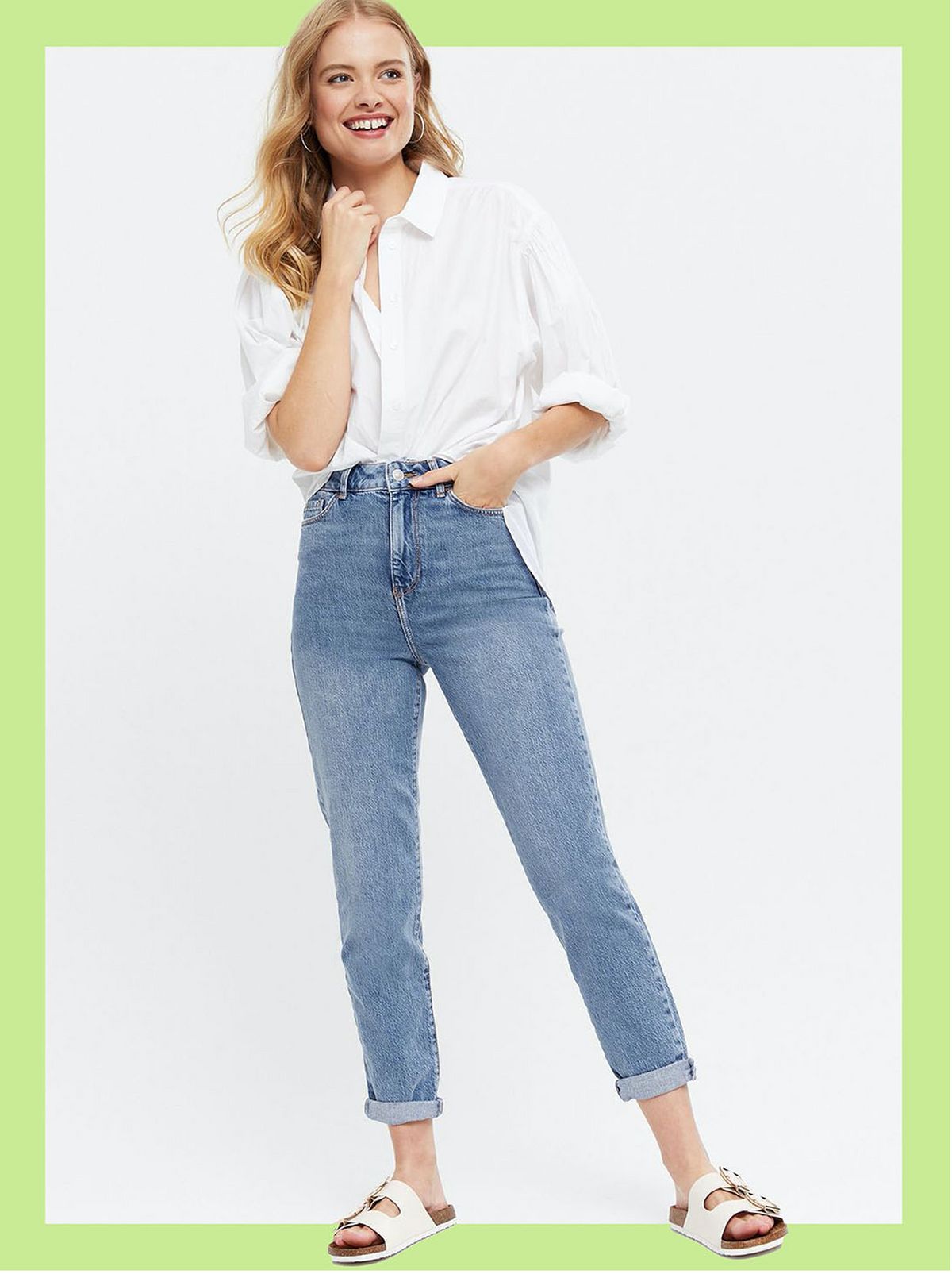 Woman wearing blue mom jeans, a white blouse and sandals