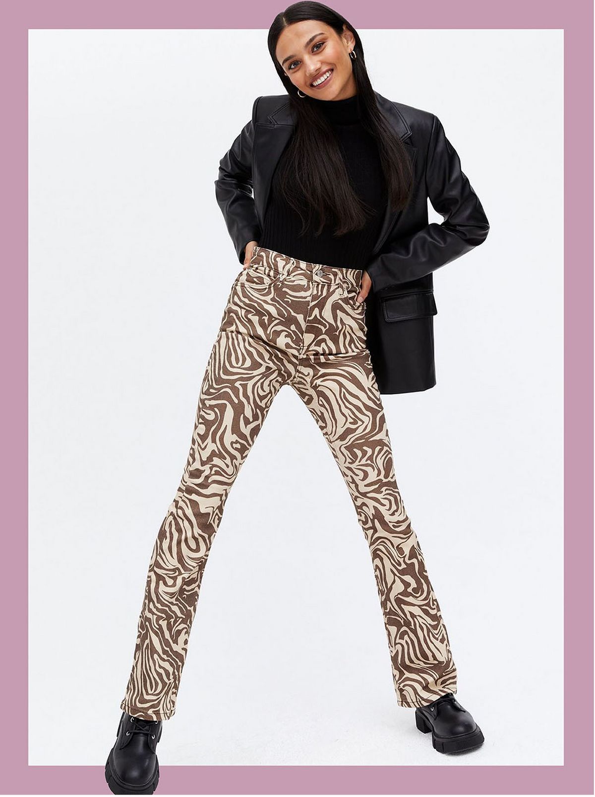 Woman wearing brown marble high waist flared jeans, black jacket, top and shoes