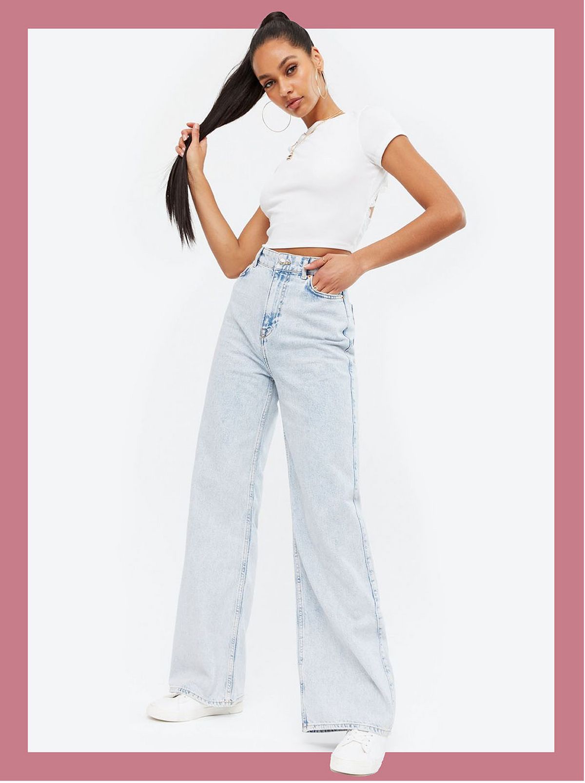 Woman wearing pale blue bleach wash high waist wide leg jean, white t-shirt and trainers