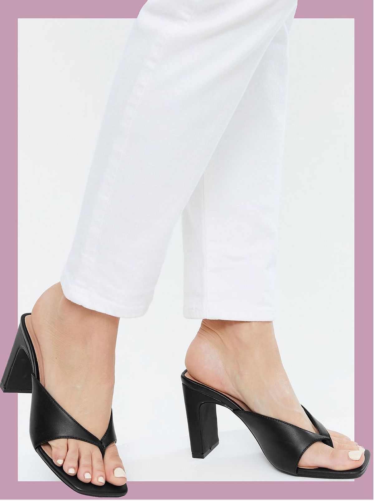 Woman wearing black leather look toe post block heel mules