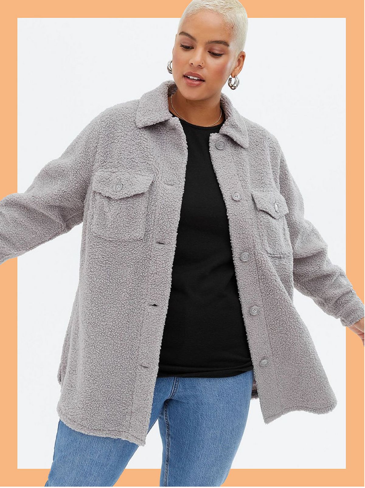 Woman wearing a grey teddy pocket front shacket, black t-shirt and jeans