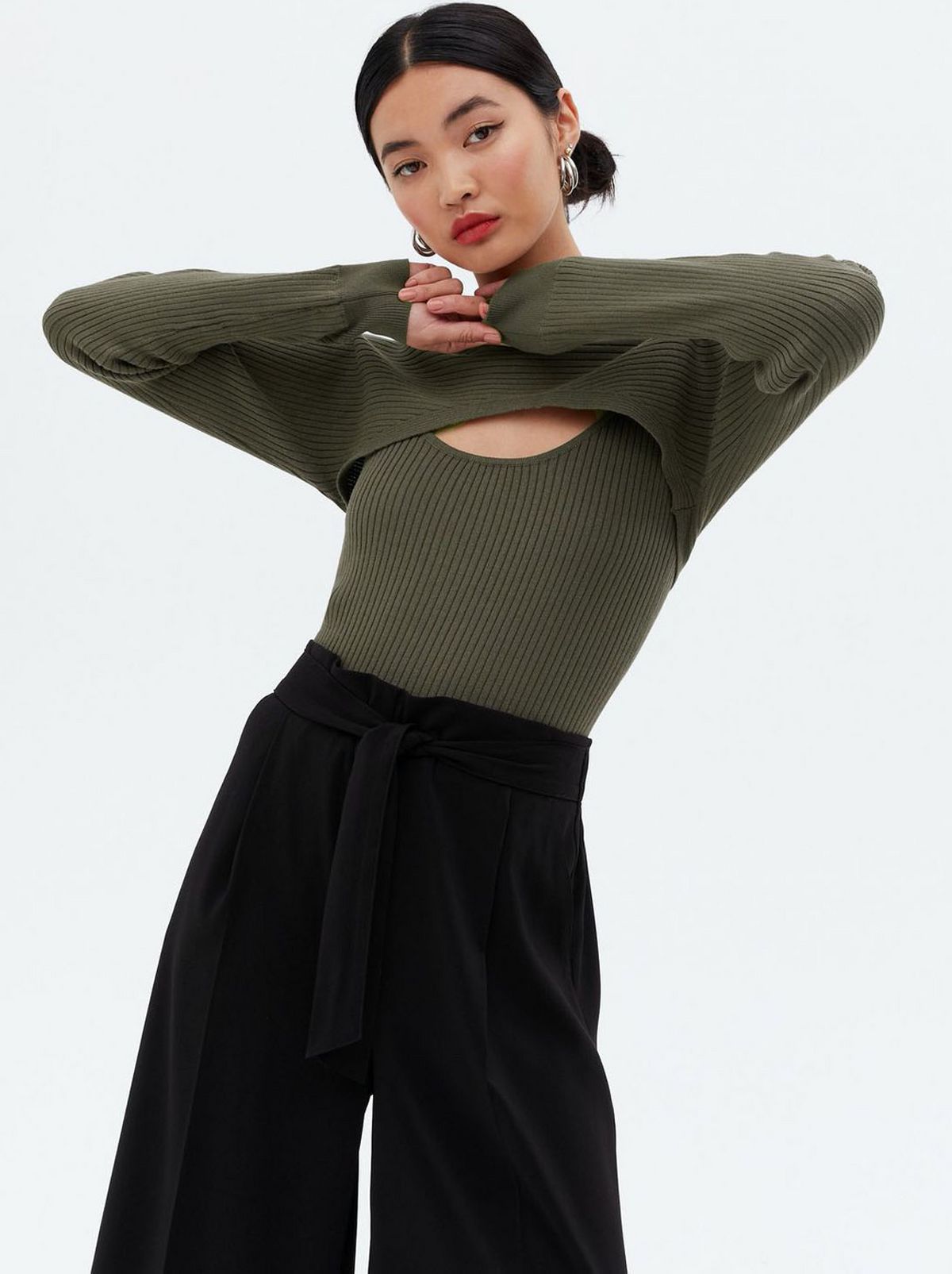 Woman wearing a khaki high neck top and trousers