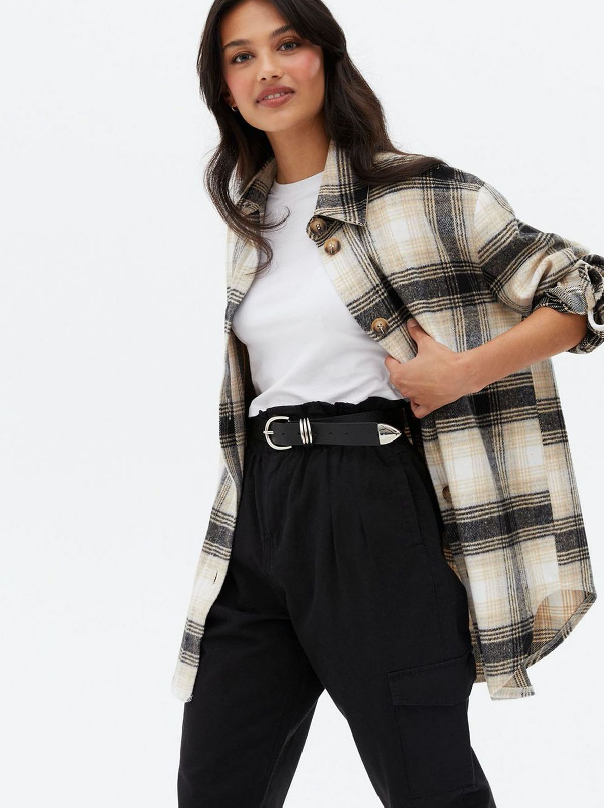Woman wearing an off white check brushed shacket, white top and black trousers