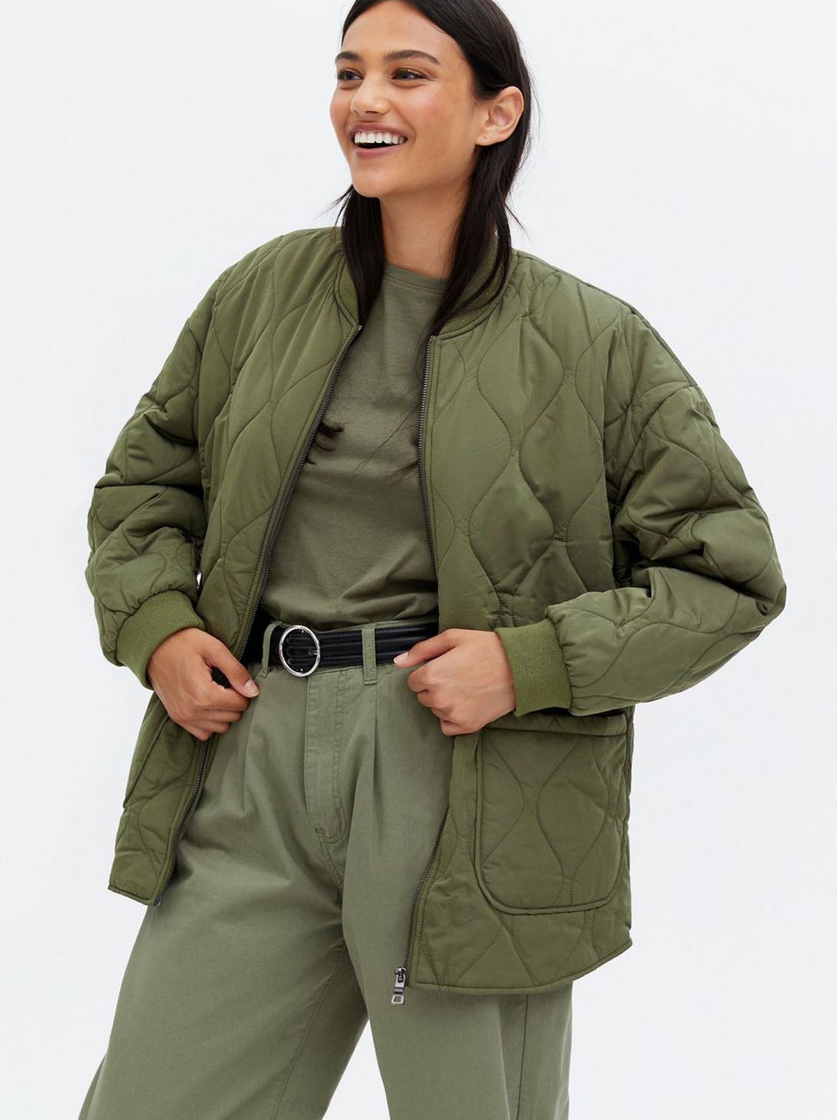 Woman wearing a khaki quilted zip jacket, khaki top and trousers
